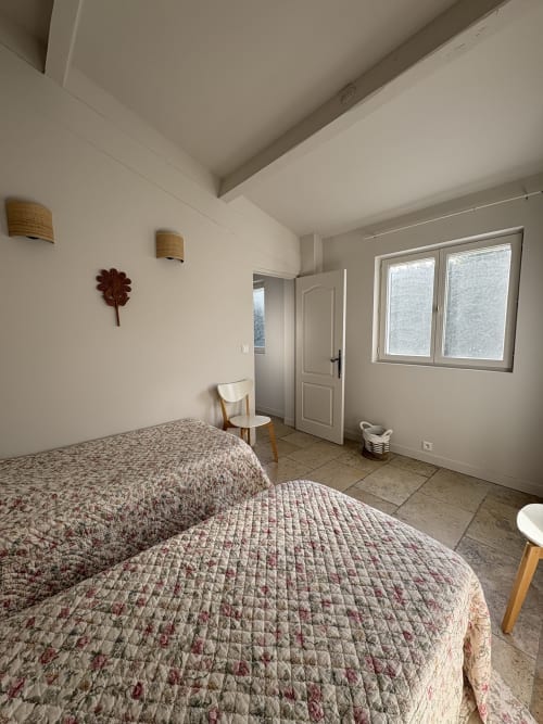 Spacieuse chambre avec deux lits au Gîte Château de Pannis à Arles, équipée de commodités modernes et vue sur le jardin