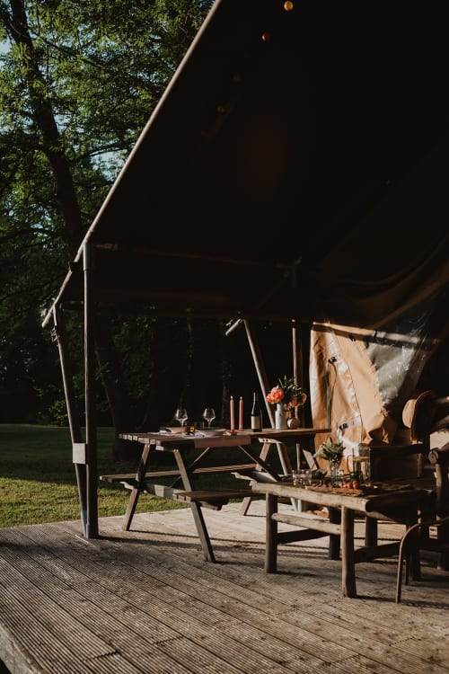Espace de restauration sous cloche glamping aux Gîtes de Cormenin, tables en bois et cadre champêtre