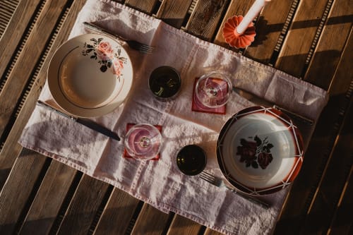 Table élégante aux Gîtes de Cormenin avec assiettes florales vintage et bougies sur plateau en bois