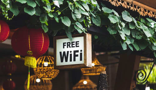 Free WiFi sign with hanging lanterns and ivy at La Borda del Gato Rafa hotel in Vielha, Spain