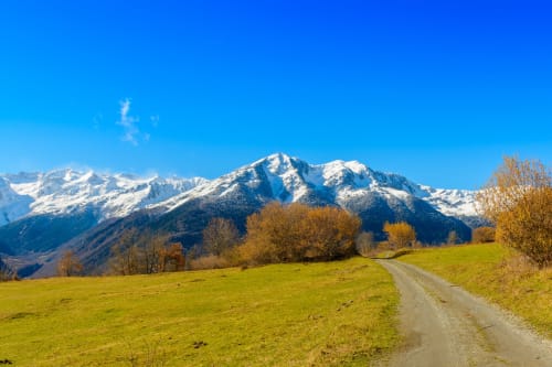Pirineos nevados sobre verdes prados cerca de Vielha, España