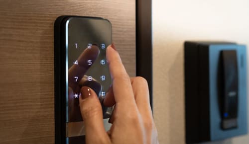 Guest entering code on digital keypad lock at La Borda del Gato Rafa hotel in Vielha
