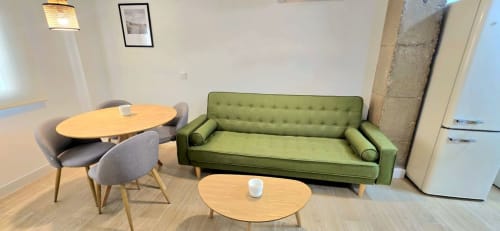 Moderno apartamento estudio en Murcia con sofá verde, mesa de comedor y cocina americana en espacio abierto