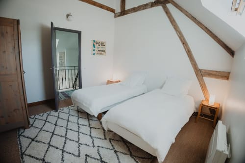 Chambre rustique aux Gîtes de Cormenin avec deux lits blancs, poutres apparentes et vue sur le jardin