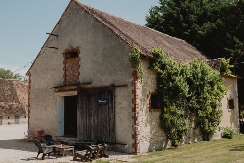 Villa rustique aux gîtes de Cormenin avec murs en pierre couverts de lierre, portes en bois sombre et coin jardin