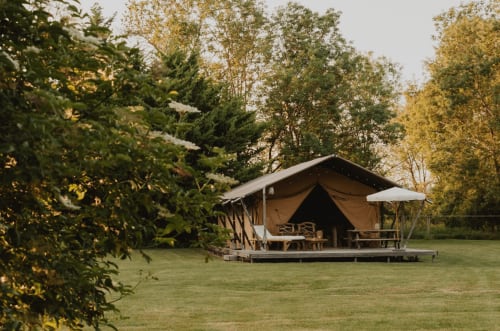 Tente de glamping aux gîtes de Cormenin à Saint-Hilaire-sur-Puiseaux entourée d'arbres d'automne