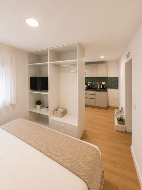 Studioapartment im Fly High, Morro Jable mit weißem Kleiderschrank, Kochnische mit dunkelgrüner Rückwand und Holzböden
