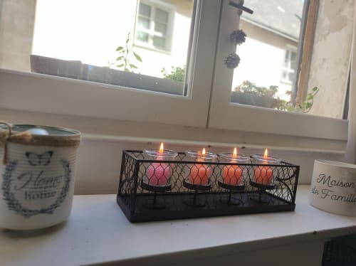 Décoration de rebord de fenêtre à la Gite de la vallée avec bougies allumées dans un porte-bougie noir et objets de décoration intérieure