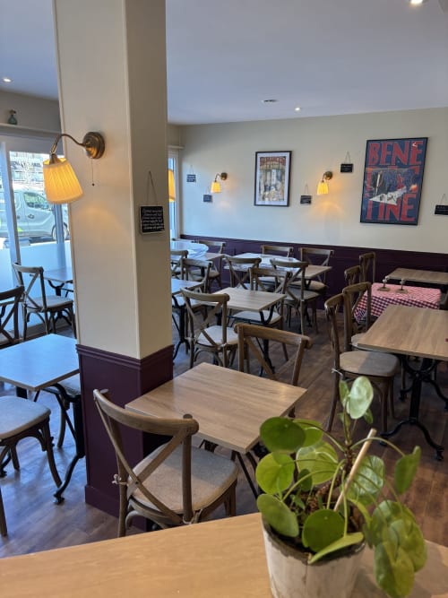 Salle à manger lumineuse du Bistrot de la Poste à Saint-Valery-en-Caux avec tables en bois, chaises bistrot et teintes jaunes