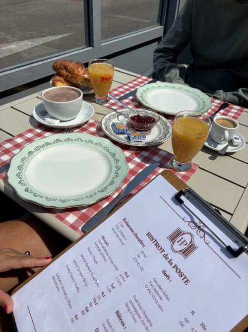 Table de petit-déjeuner à l'Hôtel Bistrot de la Poste à Saint-Valery-en-Caux avec viennoiserie, café, jus et menu