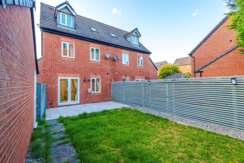Modern red brick villa at Vidale Court Manchester with spacious garden, patio, and contemporary metal fencing