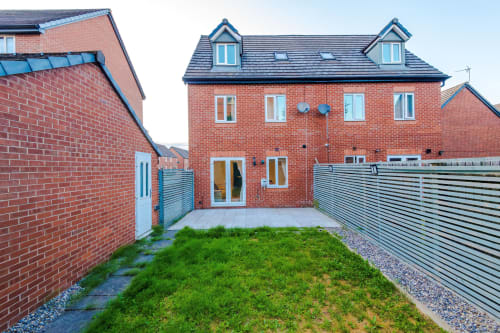 Modern red brick villa with garden at Vidale Court, Manchester. Features patio, fenced courtyard, and contemporary