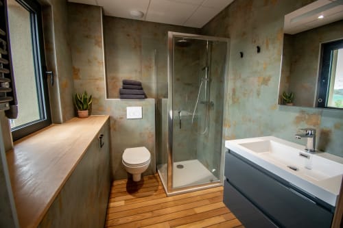 Salle de bain moderne de l'hôtel Lieu-dit Boulage à Marquefave avec douche, vasque, toilettes et parquet.