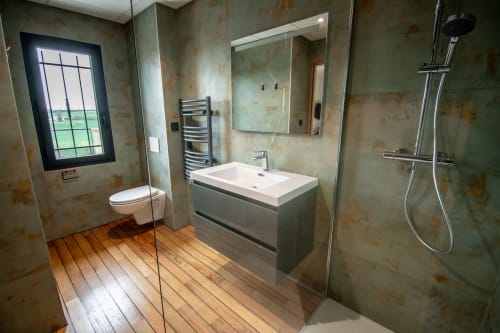 Modern bathroom at Lieu-dit Boulage hotel in Marquefave with gray vanity, rainfall shower, and rustic tile walls