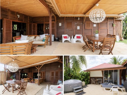 Espaces de détente extérieurs du Riviera BnB avec mobilier en bois, luminaires suspendus blancs et ambiance tropicale à Rivière Salée