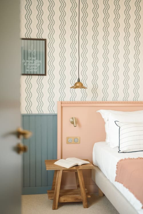 Chambre simple douillette à l'Hôtel Saint Enogat à Dinard avec papier peint ondulé, tête de lit pêche, table de nuit en bois et laiton