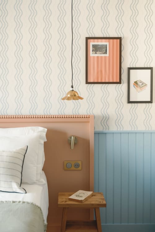 Chambre cosy de l'Hôtel Saint Enogat Dinard avec lampe suspension en laiton, œuvre d'art aux rayures corail et équipements modernes