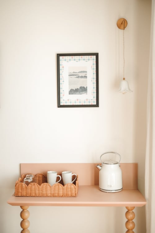 Décoration chaleureuse d'une étagère à l'Hôtel Saint Enogat à Dinard : bouilloire blanche, tasses et tableau paysager encadré