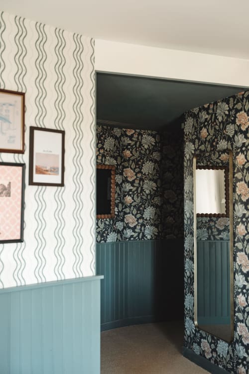 Couloir de chambre twin de l'Hôtel Saint Enogat avec papier peint floral, lambris bleu-vert et œuvres encadrées à Dinard
