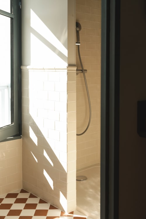 Salle de bain moderne avec douche à l'Hôtel Saint Enogat, Dinard, carrelage blanc métro et sol à motifs géométriques