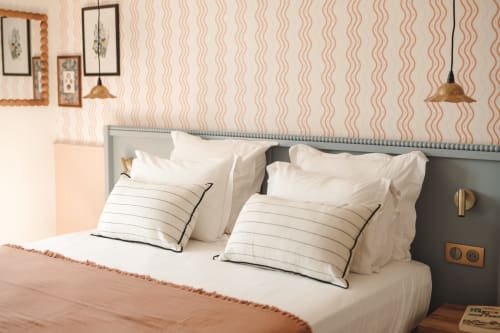 Chambre moderne de l'Hôtel Saint Enogat avec lit double, oreillers rayés, papier peint ondulé et éclairage suspendu à Dinard.