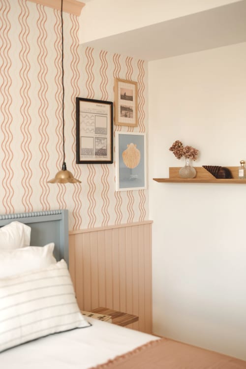Chambre moderne de l'Hôtel Saint Enogat Dinard avec papier peint motif vagues, boiseries, lampe suspendue et thème côtier