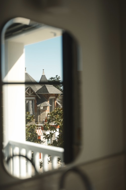 Vue de l'Hôtel Saint Enogat à Dinard à travers une fenêtre, bâtiment de style victorien avec tourelles distinctives et