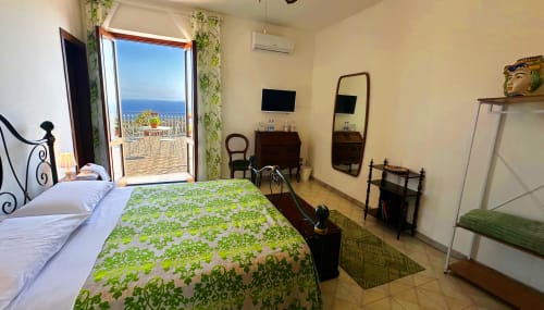 Camera Vista Mare luminosa al Pupi Catania B&B con terrazza vista mare, biancheria verde decorativa e arredi classici