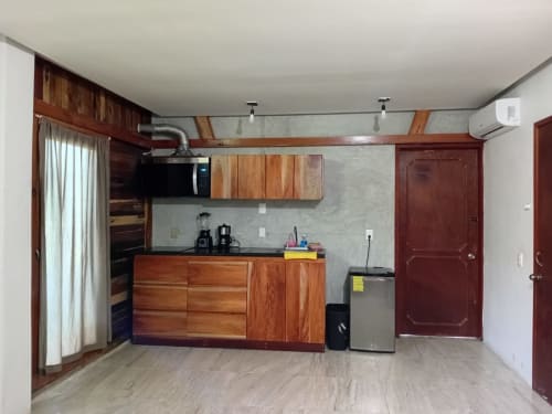 Habitación Tucán del hostel Cayuco Maya en Bacalar con pequeña cocina de madera, minibar y zona de comedor
