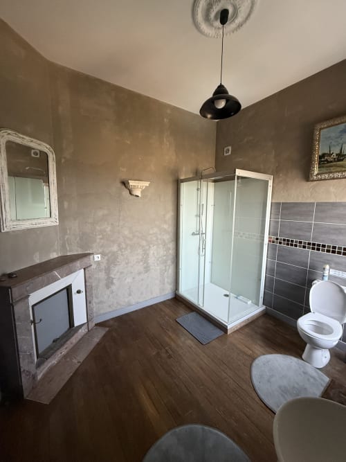 Spacieuse salle de bain familiale au Château de Montbrault avec douche, toilettes, lavabo, parquet et équipements contemporains