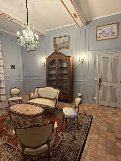 Élégant salon du Château de Montbrault avec mobilier ancien, lustre en cristal et décor raffiné