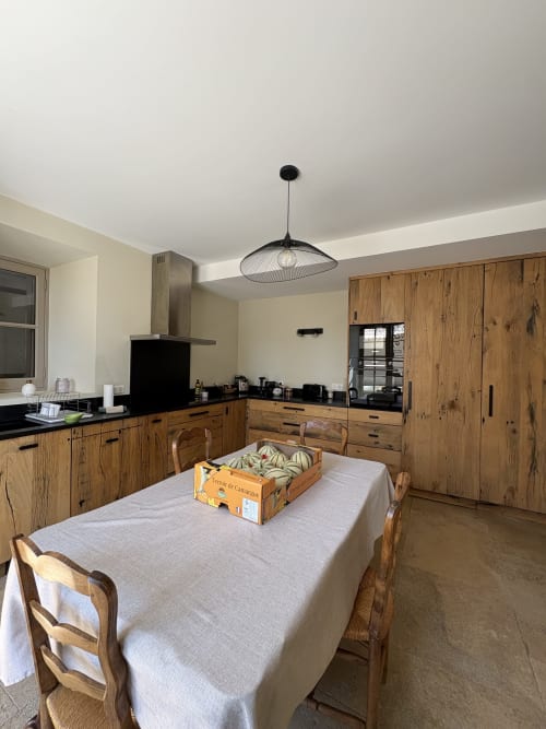 Spacieuse cuisine-salle à manger au Mas en Camargue, Arles, avec mobilier en bois, table de repas et suspension noire moderne