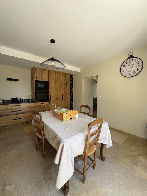 Coin repas dans la chambre Mas en Camargue à la Conciergerie Maurin, Arles, avec table en bois, chaises et cuisine