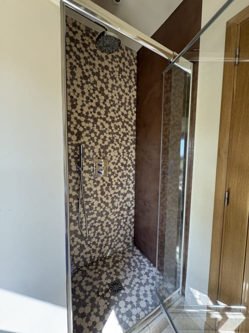 Douche à l'italienne moderne aux carreaux penny noirs et beige, pommeau de douche pluie à la Conciergerie Maurin, Arles