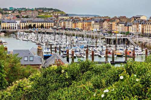 Le pittoresque port de Saint-Valery-en-Caux avec voiliers, façades colorées et falaises verdoyantes