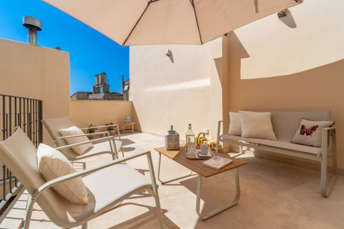 Terraza soleada en la azotea de Massa Properties en Artà con tumbonas, sombrilla y vistas al mar
