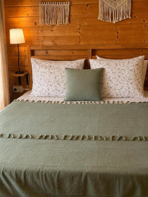 Quarto aconchegante com cama verde, almofadas florais, paredes de madeira e macramé no Bungalow de 2 Quartos da Monte da Tojeirinha