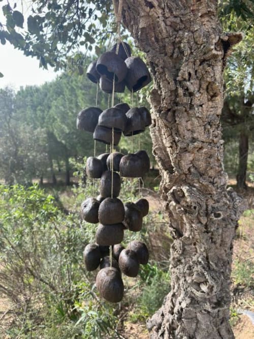 Carrilhão pendurado em árvore na Monte da Tojeirinha, refúgio à beira do lago de Montargil, Portugal