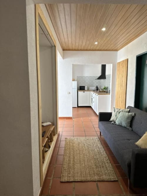 Interior moderno da villa Monte da Tojeirinha com sala integrada, sofá cinzento, cozinha, pavimento em terracota e móveis de madeira