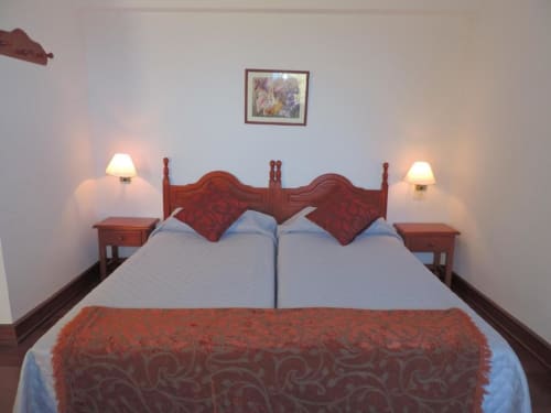 Cama doble con cabecero rojo y almohadas en el estudio de Casa Rural Los Helechos en Agulo, España