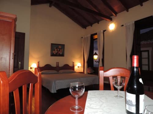 Estudio en Casa Rural Los Helechos en Agulo con cama, mesa de comedor, botella de vino e iluminación cálida