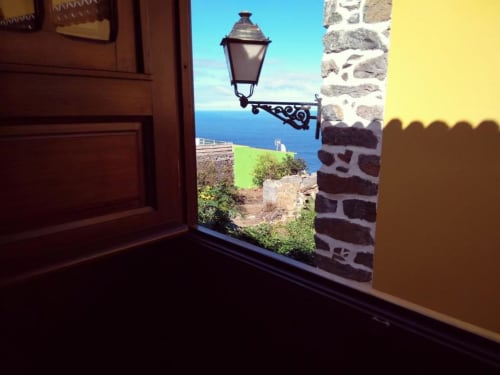 Vista desde Casa Rural Los Helechos en Agulo: paisaje costero, linterna y arco de piedra enmarcan el océano