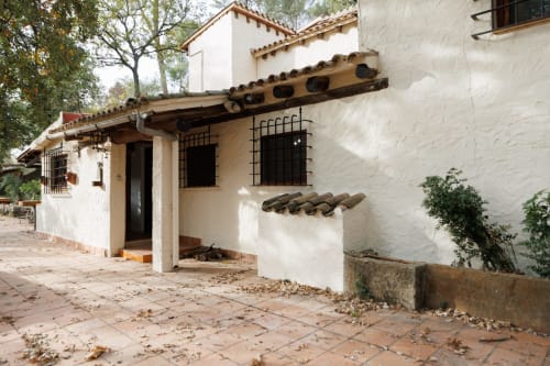 Entrada de Masías Can Trabal en Olerdola: edificio colonial encalado con tejas de barro y arcos