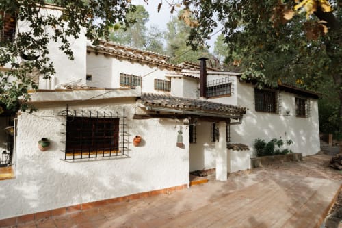 Exterior encalado de Masías Can Trabal con patio de terracota y arquitectura tradicional española en Olérdola