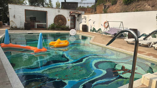 Piscina con mural artístico subacuático en el hotel Masias Can Trabal de Olerdola, España, con tumbonas