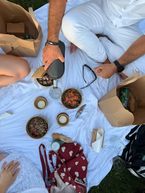 Outdoor picnic spread at Domaine De Campagnac with appetizers, wine, and guests enjoying lunch in Carsac-Aillac