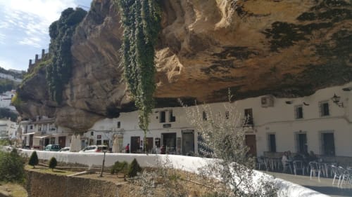 Exterior del hotel cueva La Joya de Setenil con edificio blanco excavado en espectacular acantilado rocoso en Setenil de las Bodegas, España