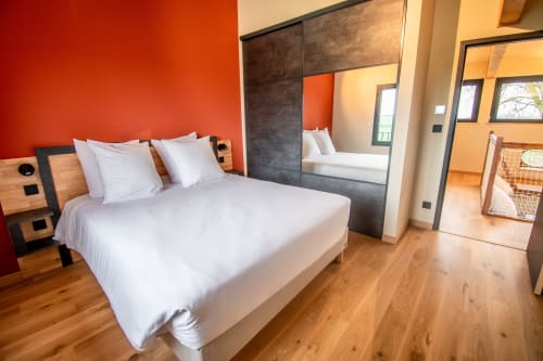 Modern bedroom in Duplex Boulage apartment at Lieu-dit Boulage hotel, Marquefave, with red accent wall and mirrored wardrobe