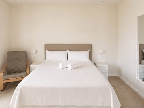 Dormitorio moderno en apartamento ModulSuites de Baiona con cama queen, decoración neutral y mobiliario contemporáneo