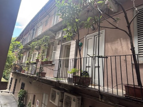 Esterno dell'appartamento Lovelyloft a Milano con balcone, facciata ricoperta di edera e architettura italiana tradizionale